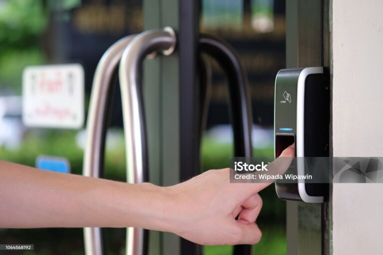 Close up of man hand using biometric fingerprint scanner for track employee hours.